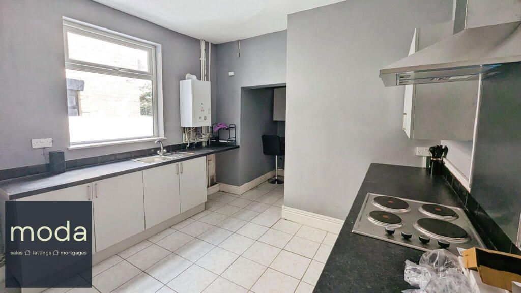Kitchen with white cabinets, gray walls, and a stainless steel stovetop.