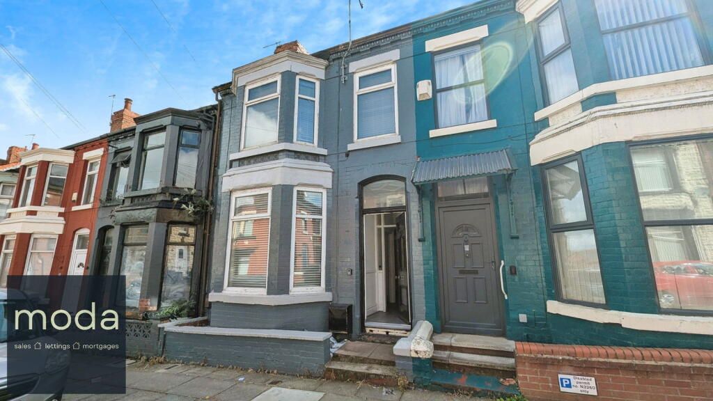 Row houses in various colors, one with a bay window and steps. 