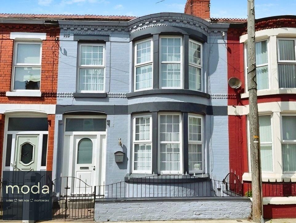 Row of colorful townhouses; the middle one is blue with a bay window, white trim, and a white door.