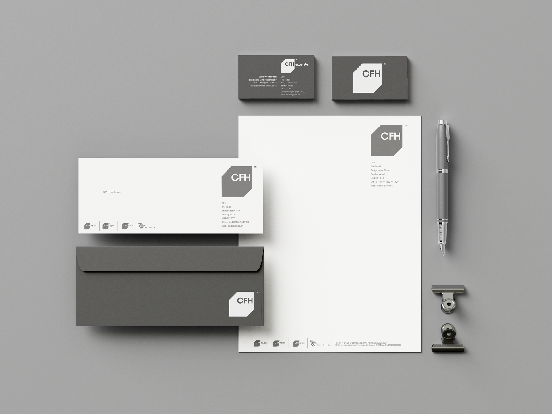 Minimalist stationery mockup: gray and white envelopes, note cards, pen, and small clip on a light background