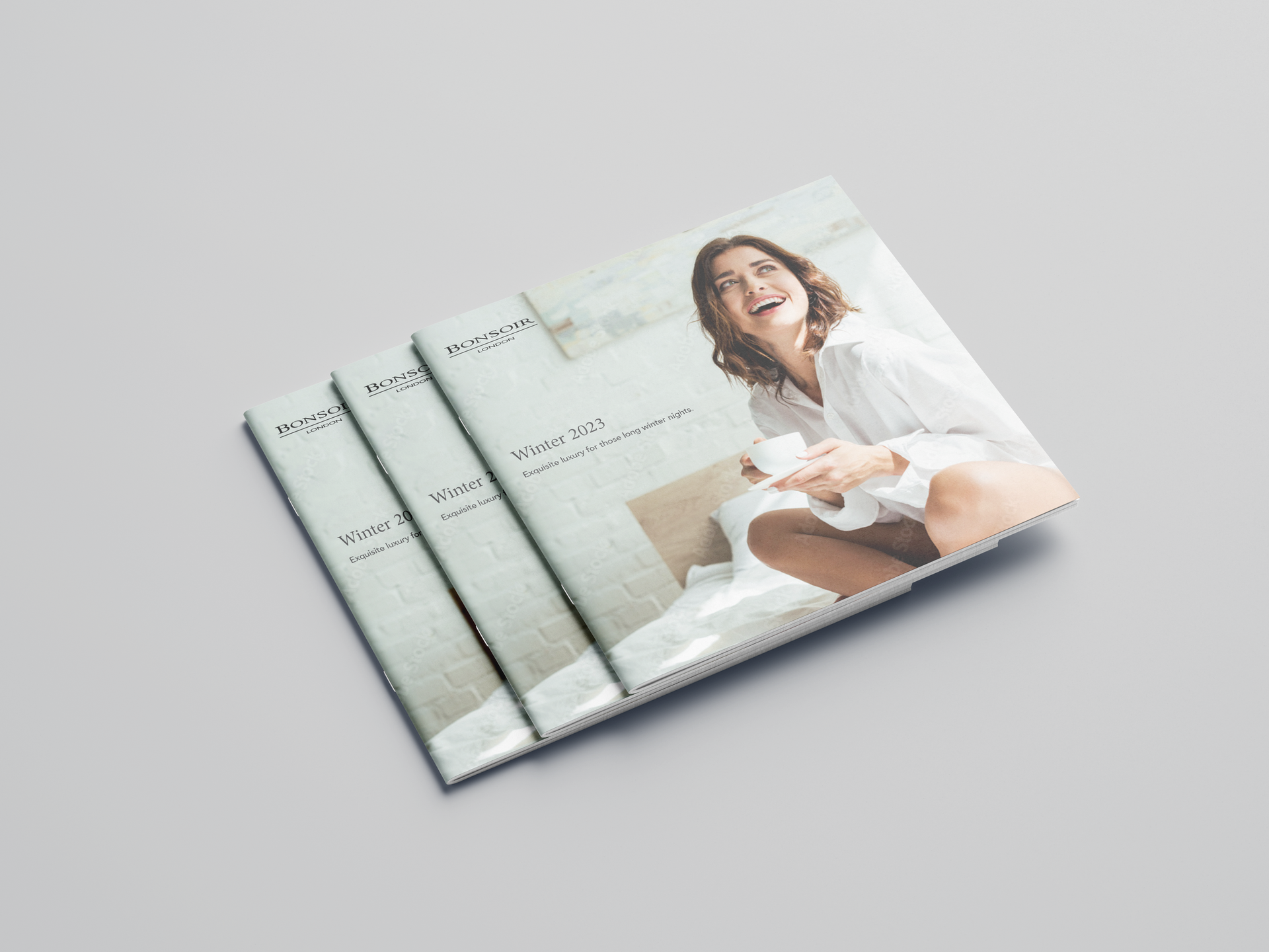 Three stacked brochures with a smiling woman on the cover against a light background