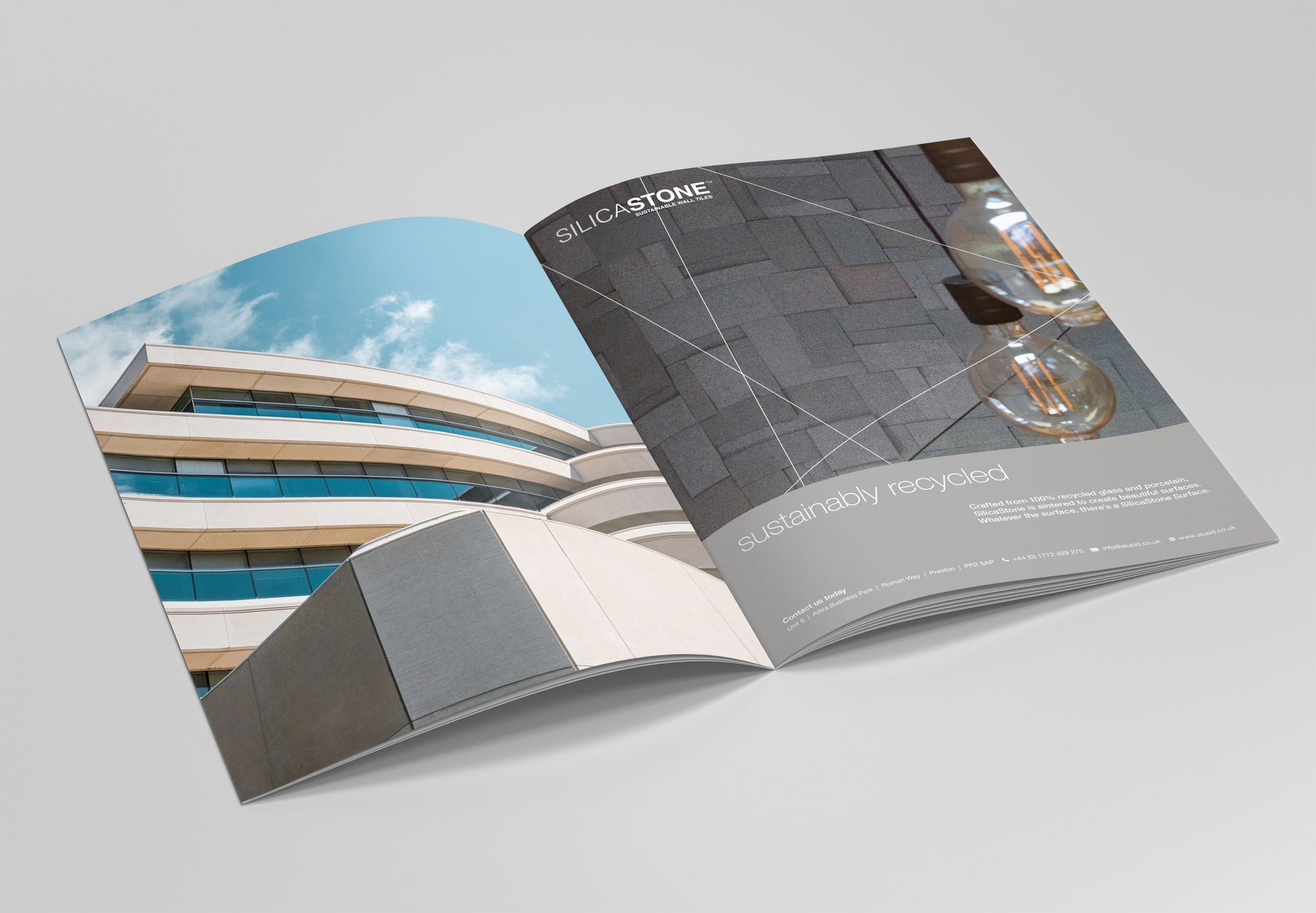 Open brochure showing a modern building exterior and a dark textured page with small text.
