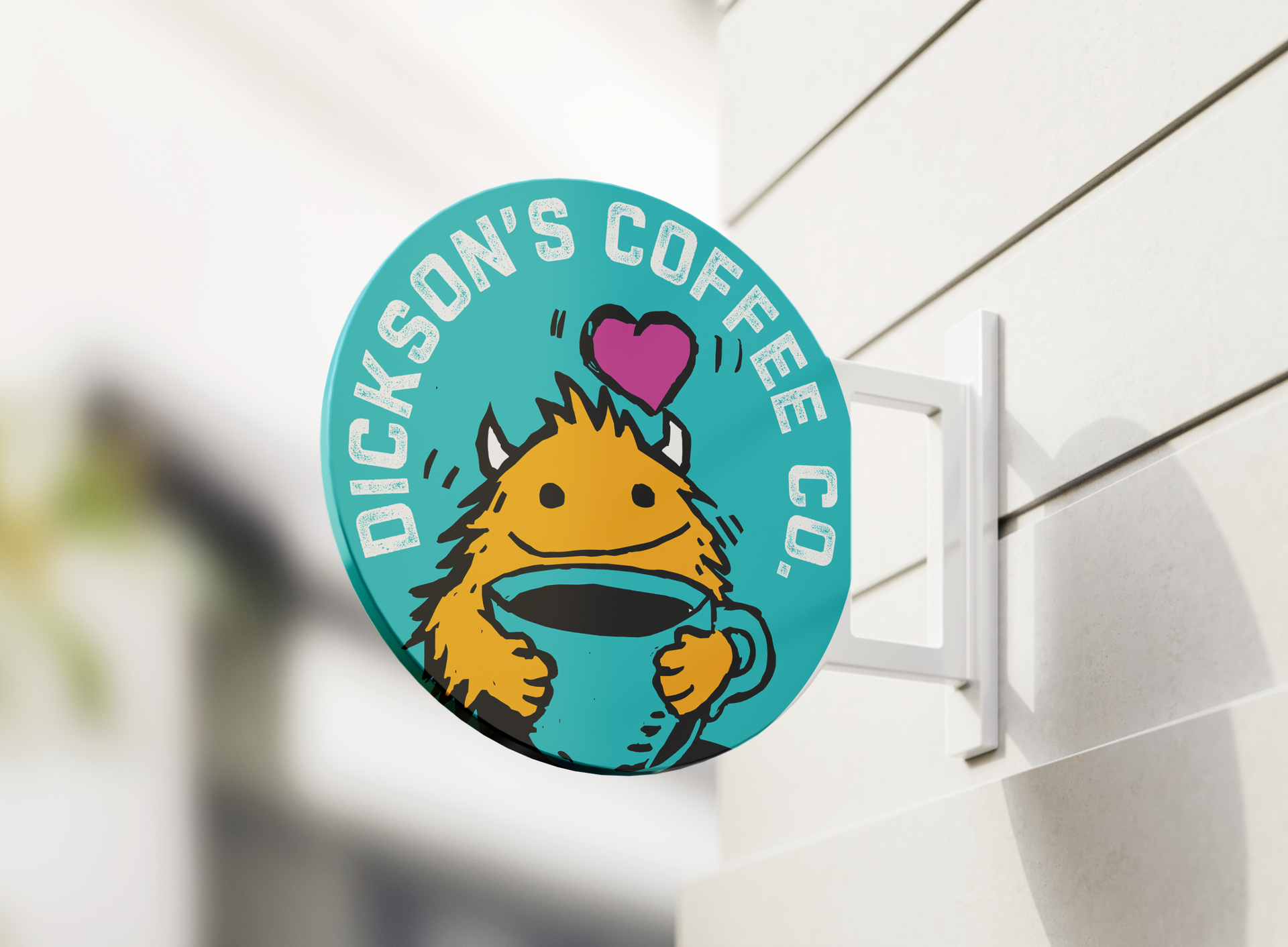 Round turquoise coffee shop sign with a smiling orange mascot holding a cup and a pink heart, reading “Dickson’s Coffee Co.”