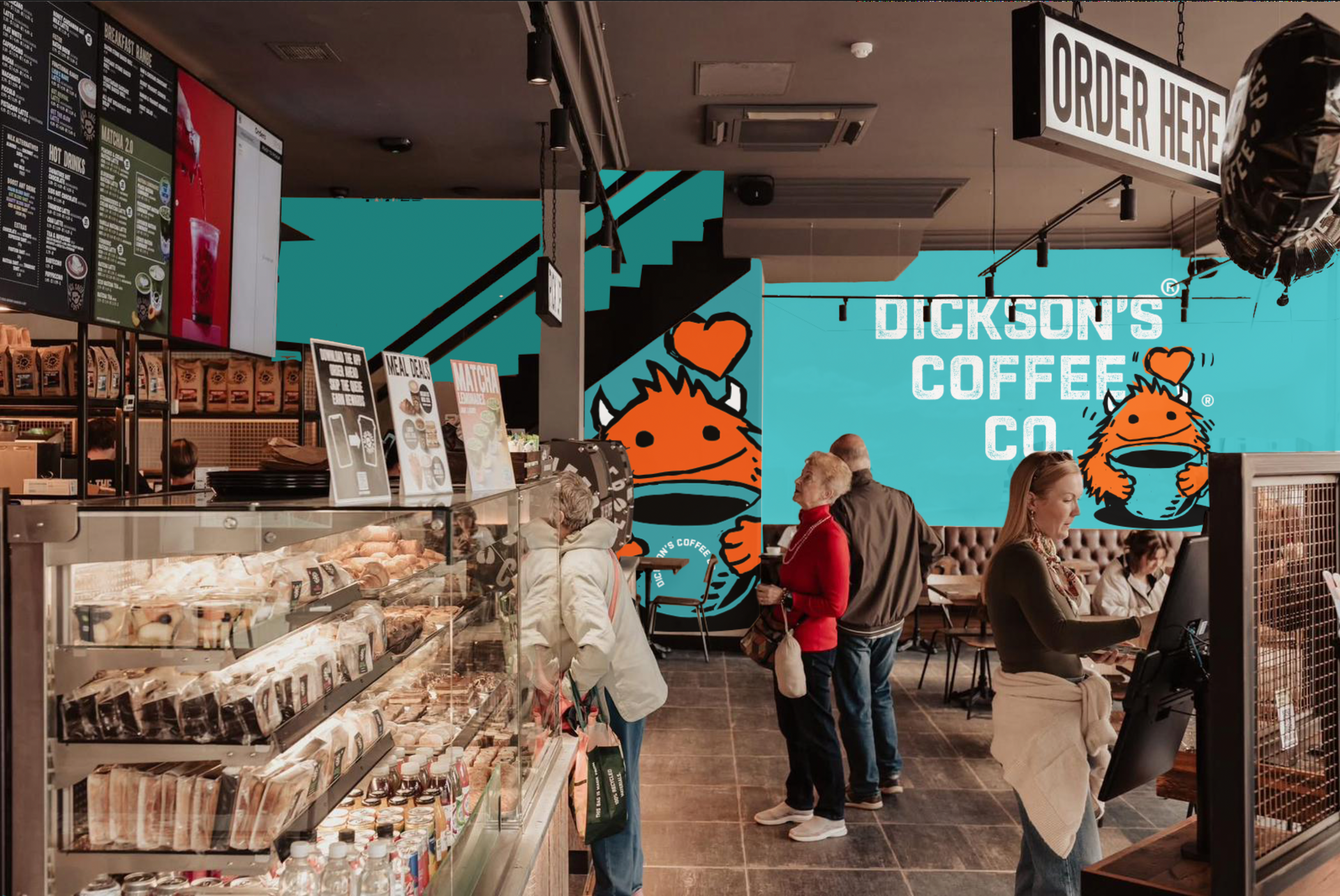 Coffee shop interior with display cases, customers, and a turquoise mural reading “DICKSON’S COFFEE”
