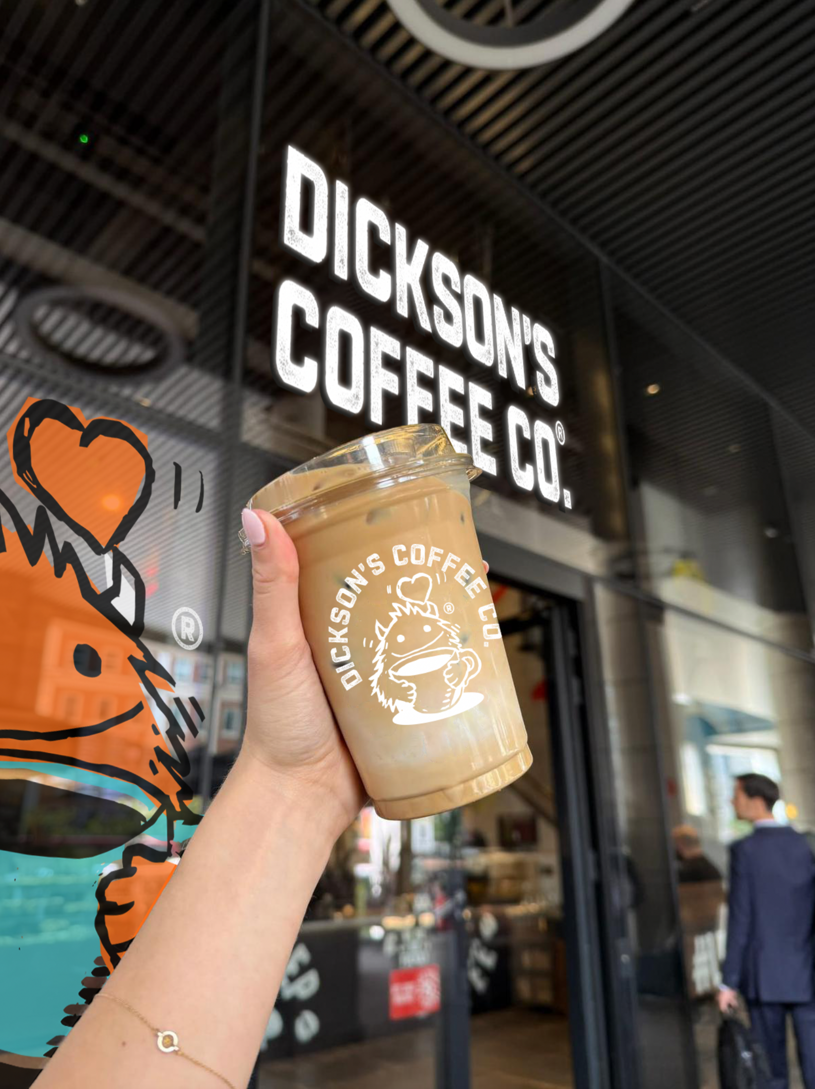 Hand holding a coffee cup outside Dickson’s Coffee Co. storefront with orange graffiti art