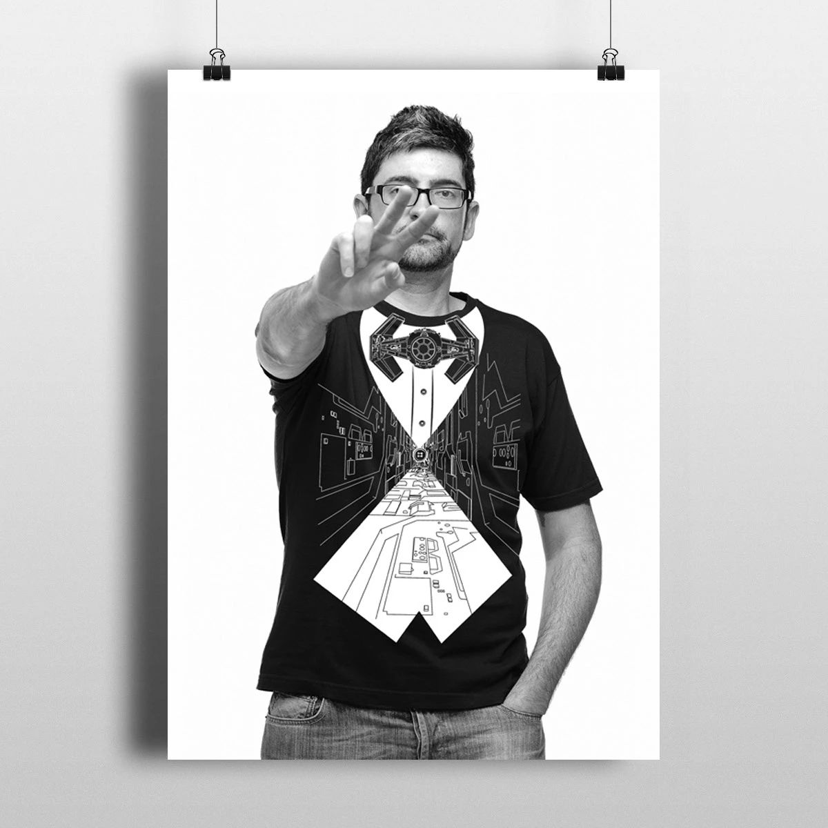 Man in glasses and black shirt holding up two fingers in a black-and-white portrait