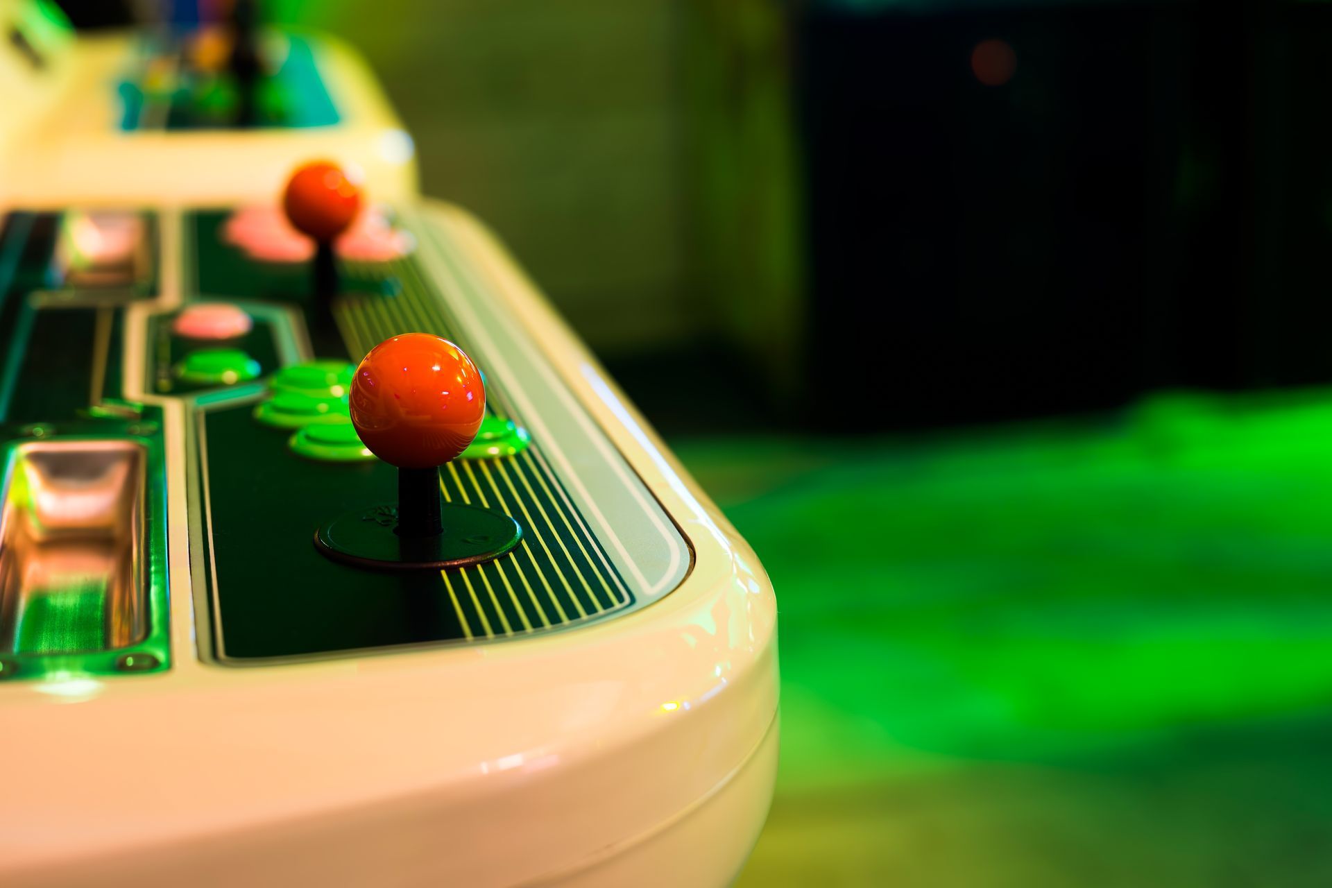 Close-up of a red joystick and buttons on a vintage arcade game machine.