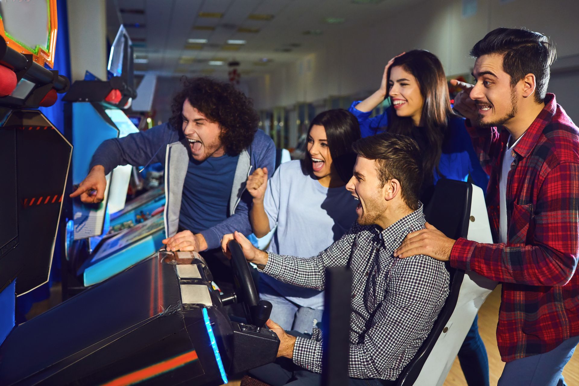 A group of friends playing arcade machine. A group of friends playing arcade machine.
