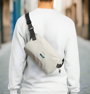 A man wearing a white sweatshirt and a sustainably sourced cross-body bag