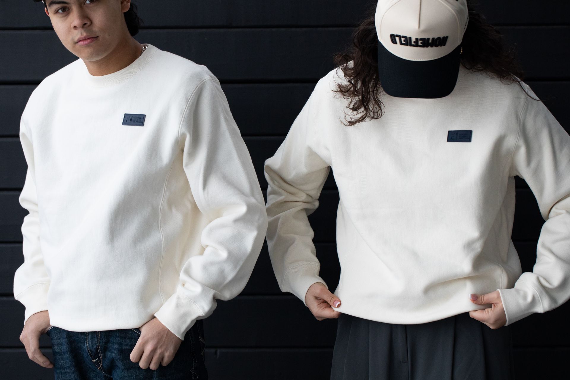 A man and a woman wearing white sweatshirts and hats standing next to each other
