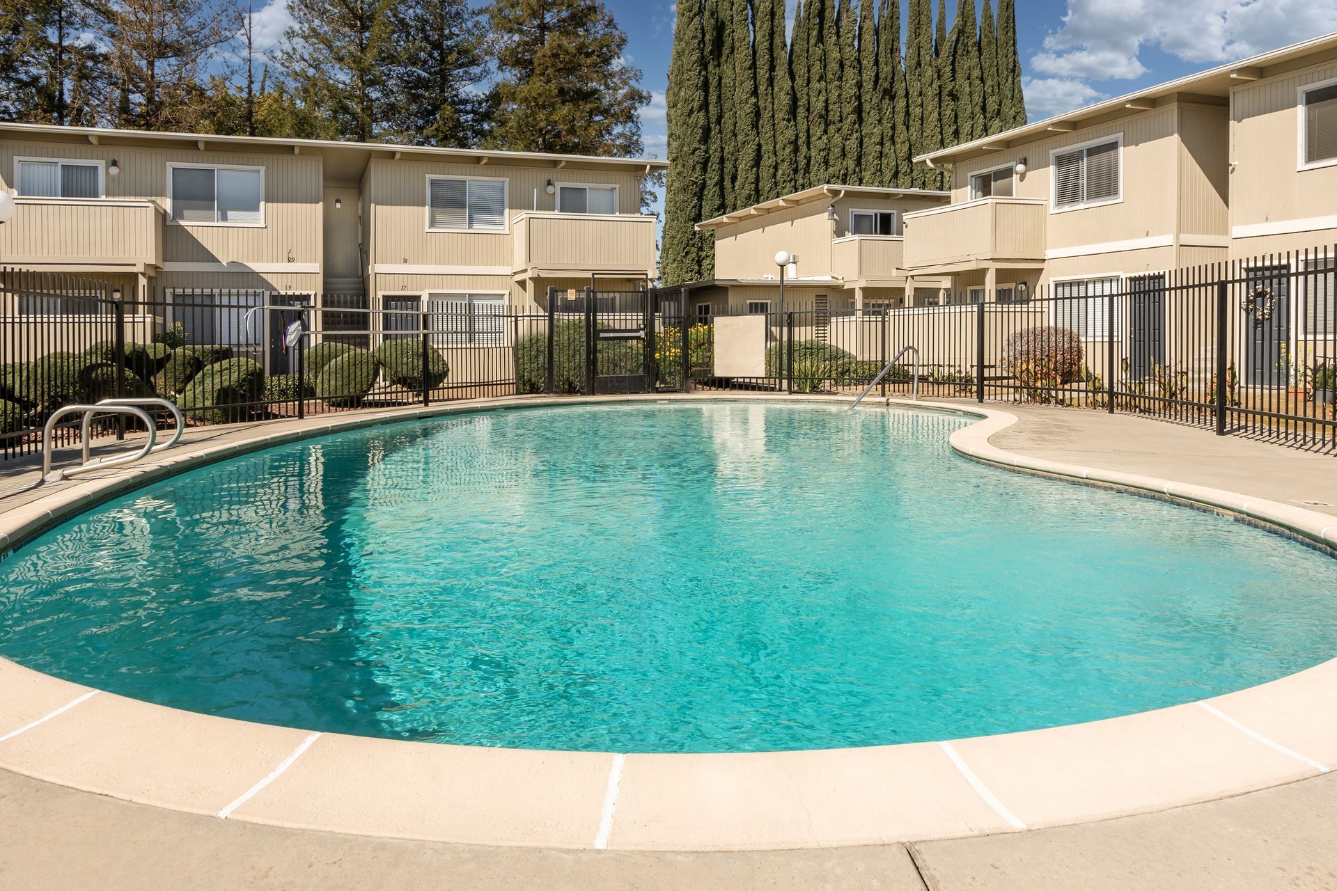 Swimming pool in front of apartment complex with turquoise water.
