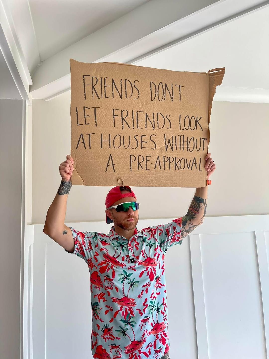 Man in a tropical shirt holds a sign: 