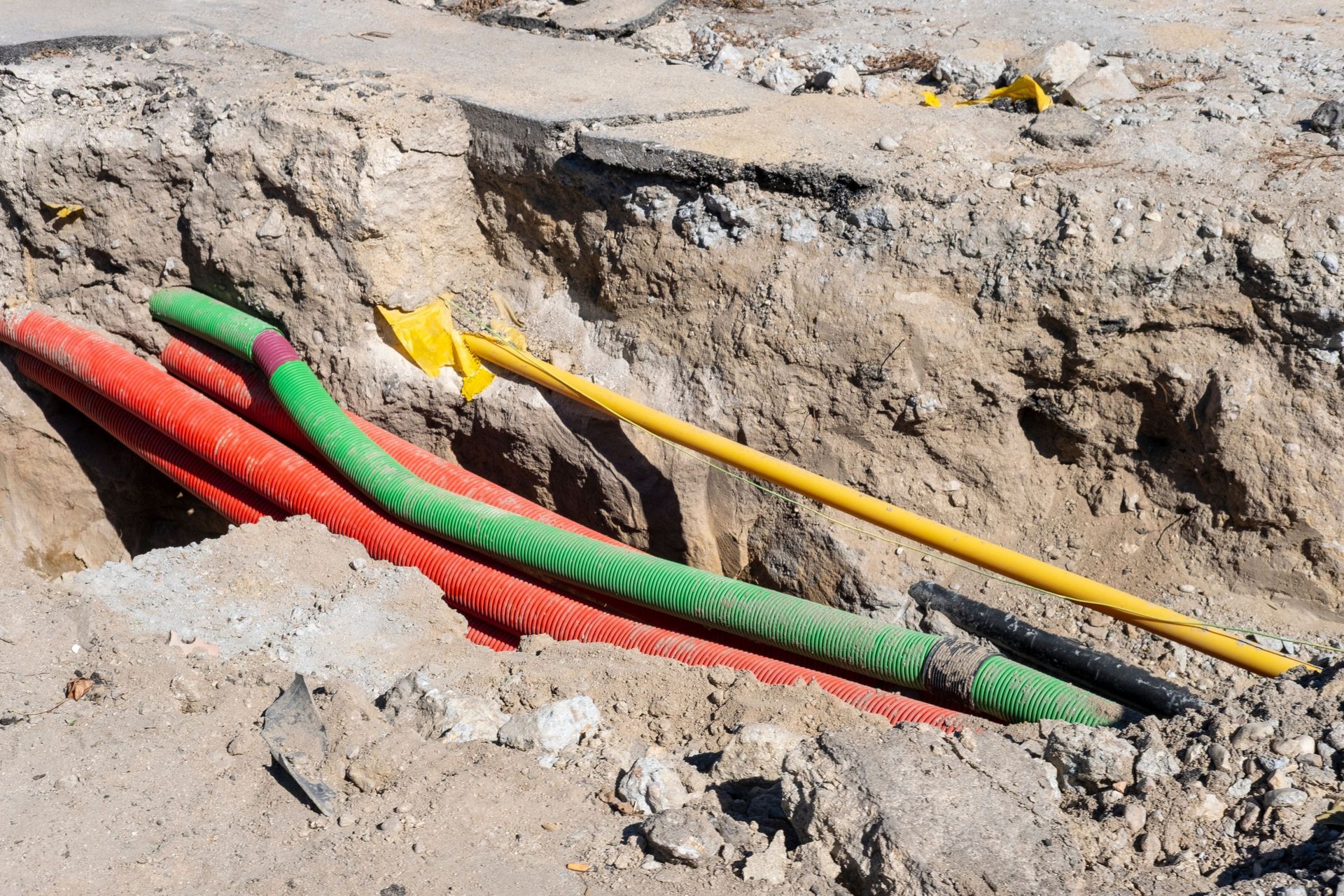 Colored pipes laid in a dirt trench at a construction site Colored pipes laid in a dirt trench at a construction site