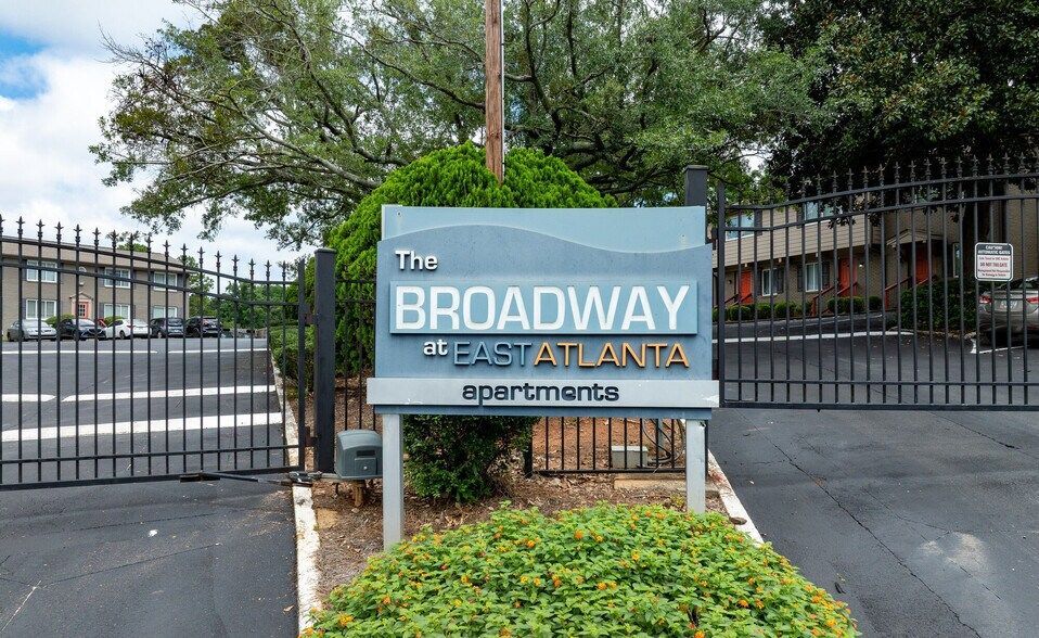 Sign for The Broadway in Atlanta at a gated entrance with trees and shrubs