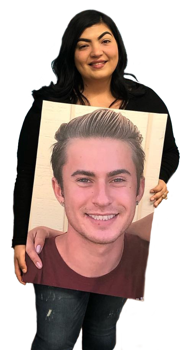 A woman is holding a picture of a man 's face.
