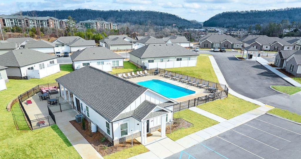 An aerial view of a residential area with a swimming pool surrounded by houses.