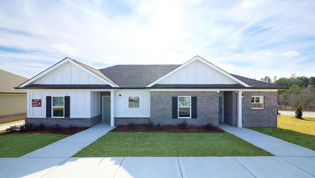 A brick house with a white roof and black shutters is for sale.