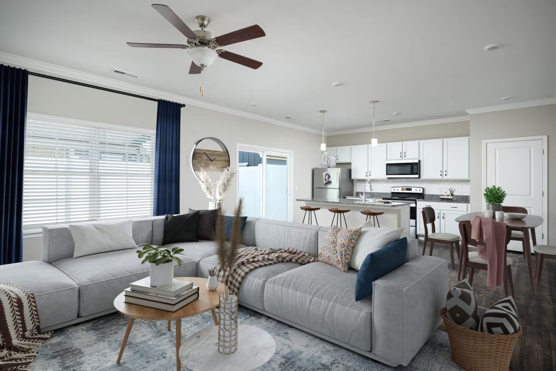 A living room with a large sectional couch and a ceiling fan.