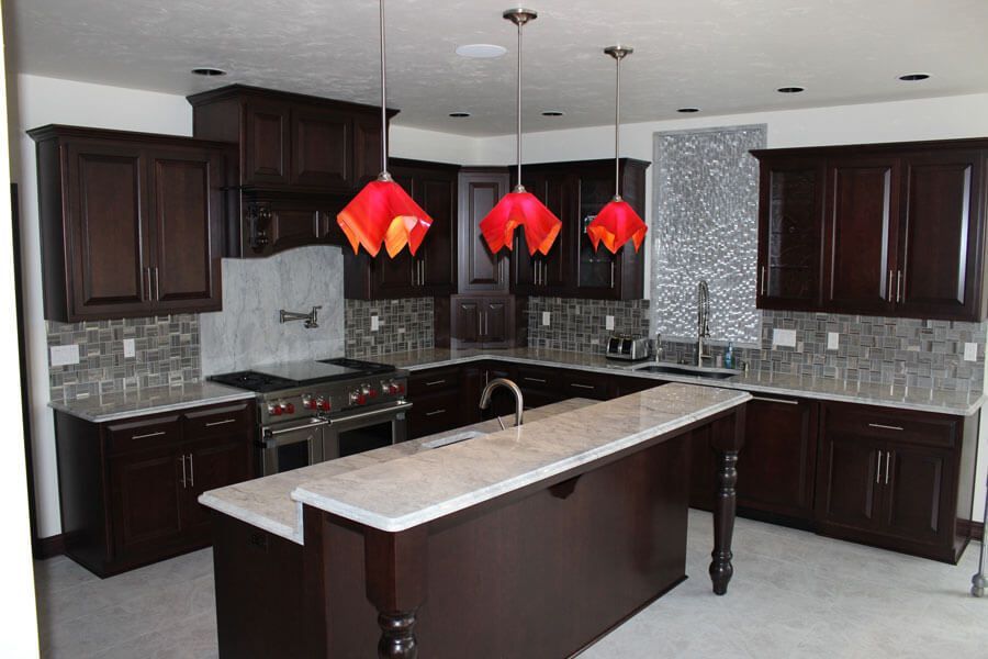 Modern kitchen with dark wood cabinets, gray tile backsplash, island, and red pendant lights