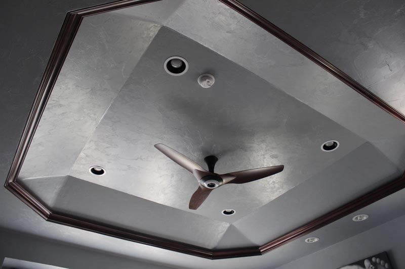 Ceiling with a dark wood trim and a central ceiling fan with recessed lights