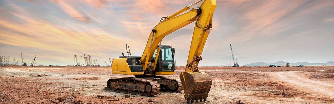 A yellow excavator is driving through a field — Line Boring in Chevallum, QLD