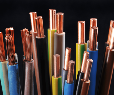 Close-up of multicolored electrical wires with exposed copper ends against a dark background
