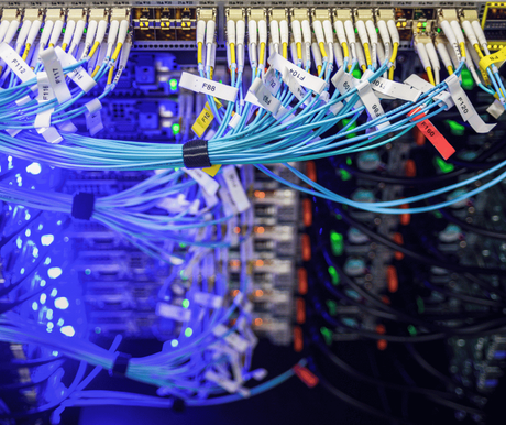 Blue-lit network cables plugged into a server rack