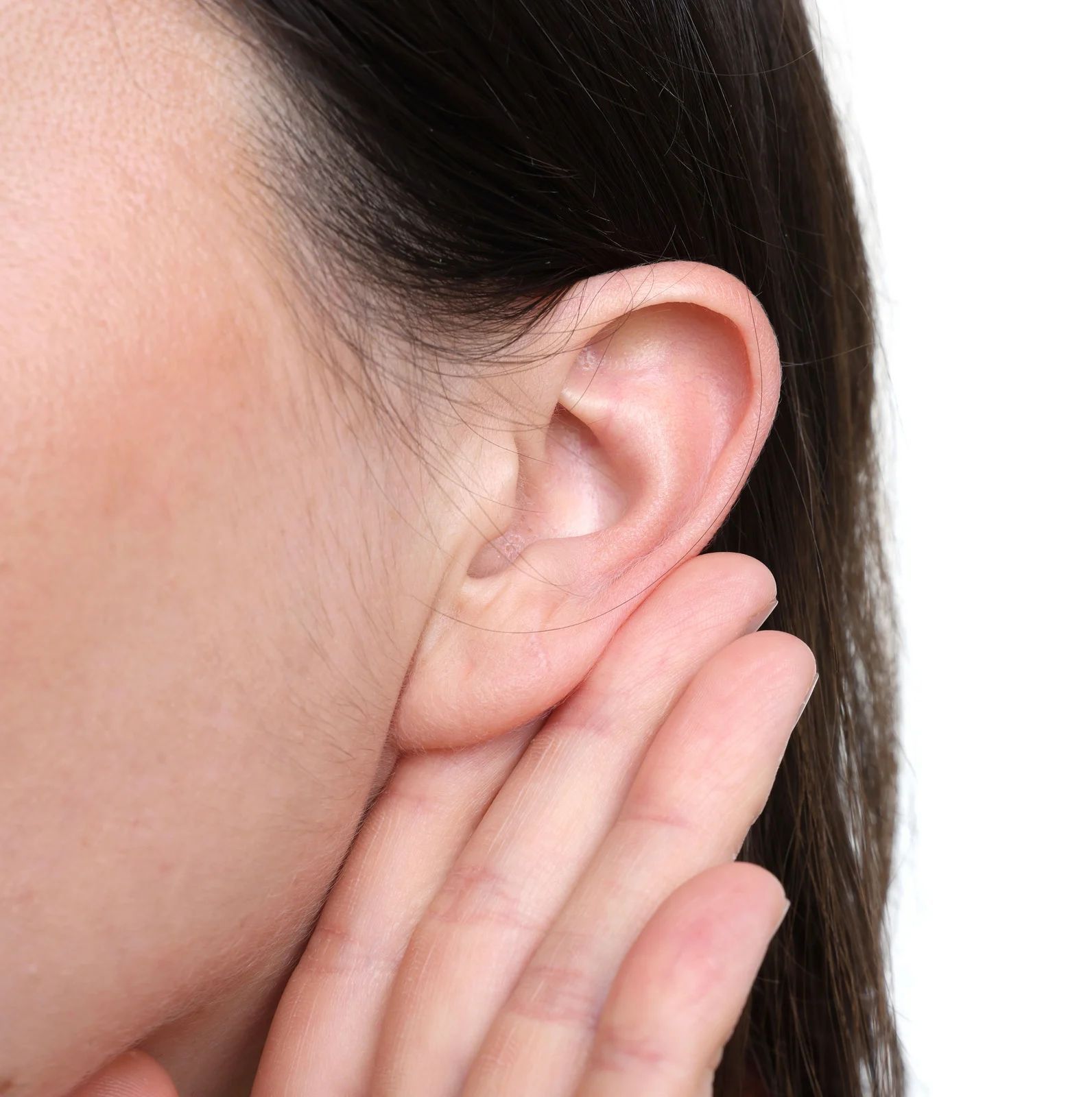 A person holding their hand up to their ear as if listening closely.