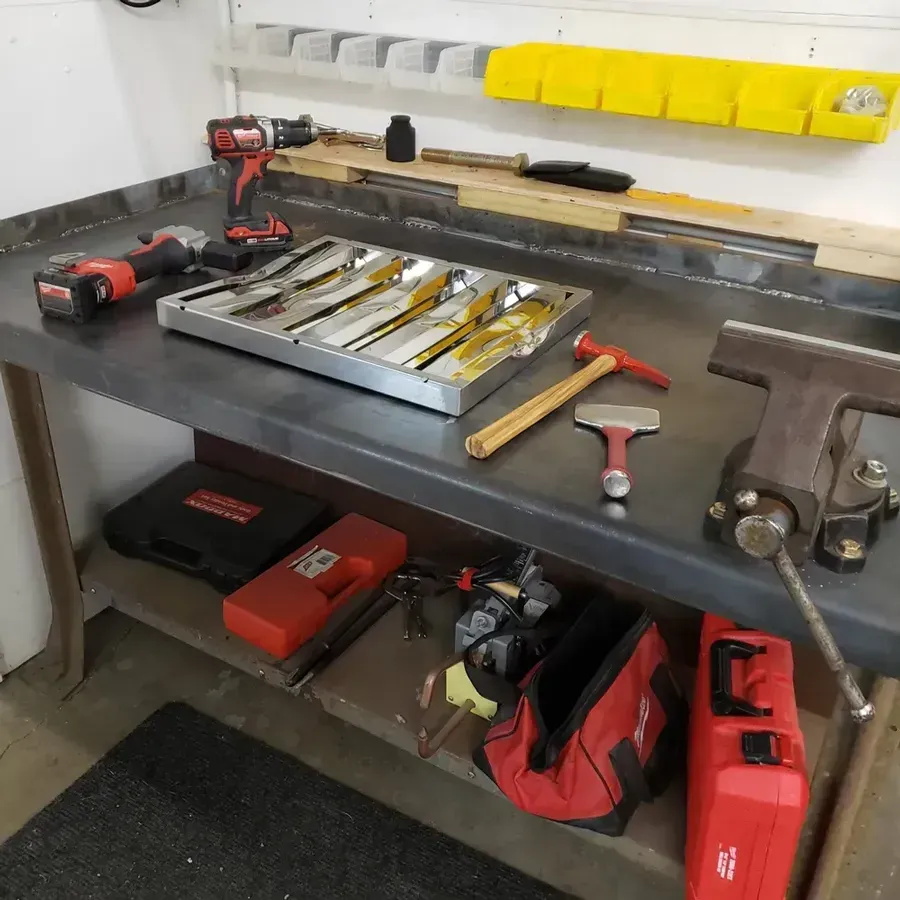 A tray of tools sits on a workbench in a garage