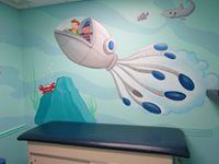 Blue-and-white fish mural with a child in the cockpit, above a teal bench in a room