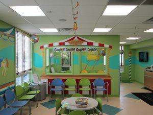 A waiting room with a carnival theme and a table and chairs.