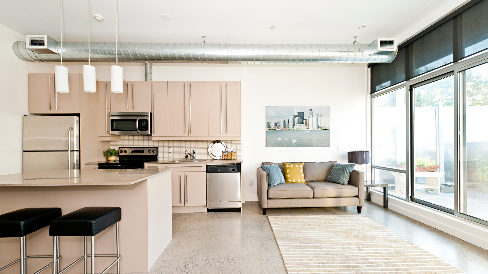 Bright modern apartment with kitchen, beige sofa, and floor-to-ceiling windows