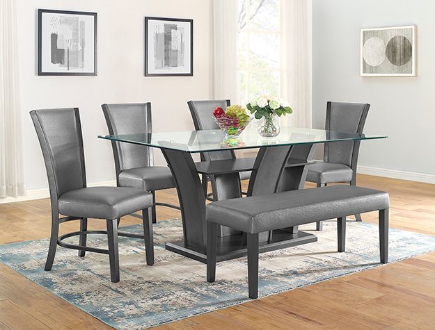 Modern dining room with a glass-top table, gray chairs, bench, and floral centerpiece on a rug