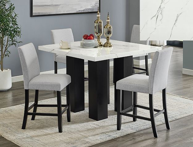 Modern dining table with four gray chairs, black legs, and gold decor in a bright room