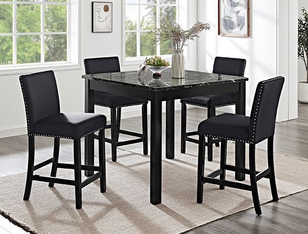 Black dining table with four matching chairs in a bright, modern room