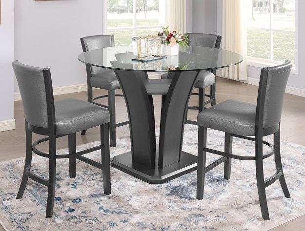 Modern glass-top dining table with four gray chairs in a bright room