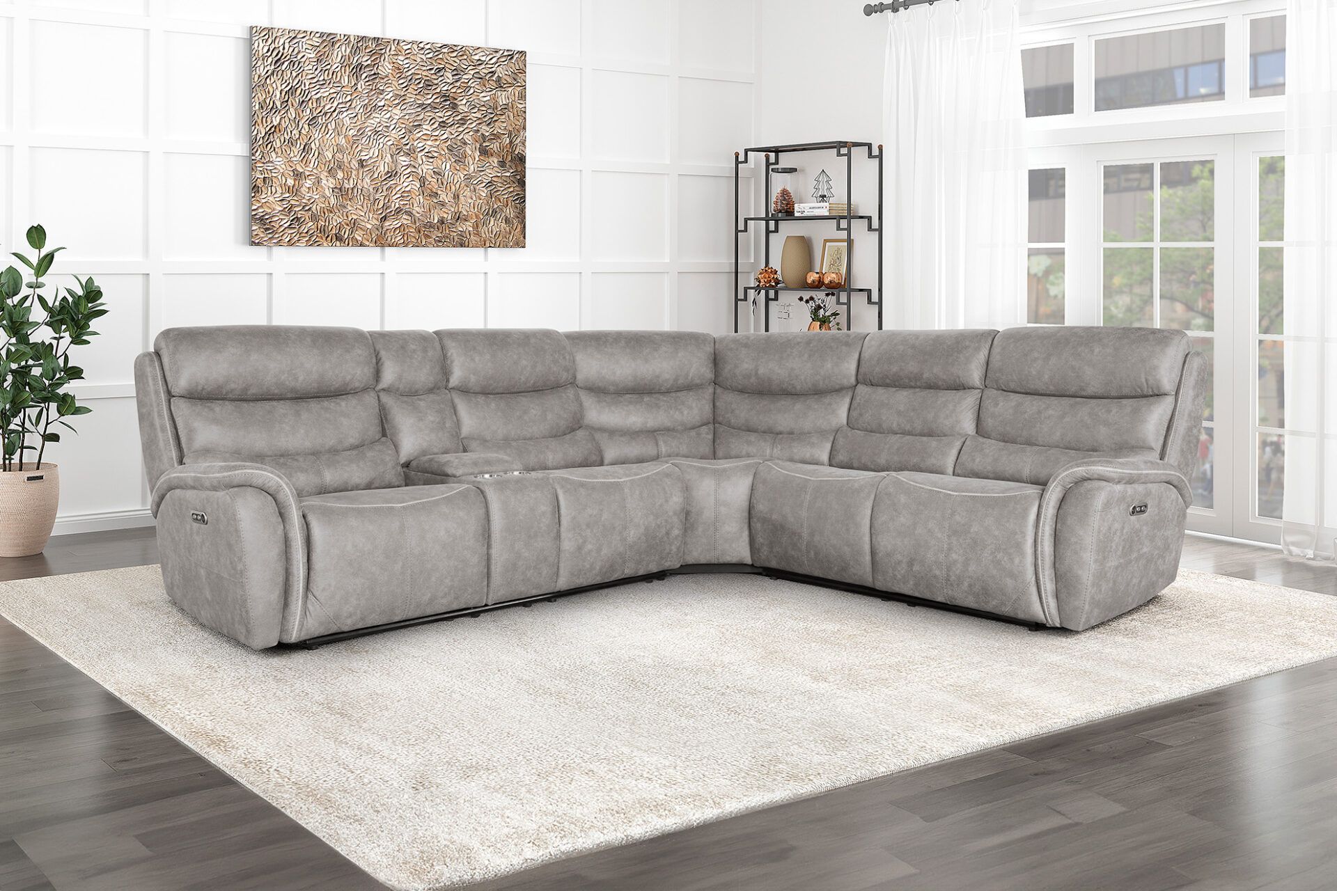 Gray sectional sofa in a bright living room with white rug and large windows