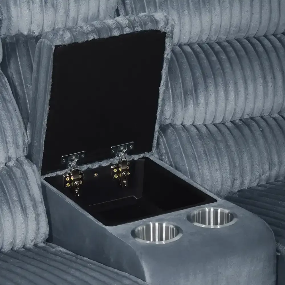 Open storage compartment with two metal cup holders in a gray tufted car interior