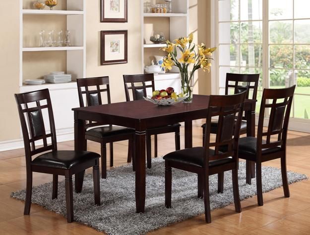 Dining room with dark wood table and six chairs, a floral centerpiece, and shelves by a bright window.