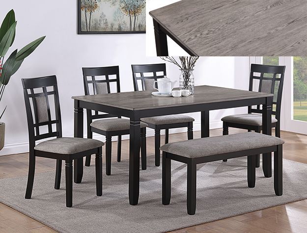 Dark wood dining table set with four chairs and two benches on a light rug in a modern room