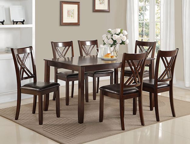 Dark wood dining table with six chairs in a bright room, set with a white floral centerpiece.