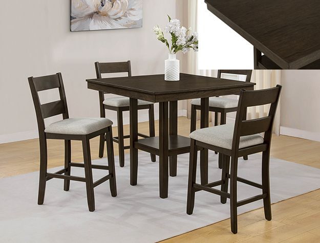Dark wood dining table with four matching chairs in a bright room, with a white flower vase centerpiece