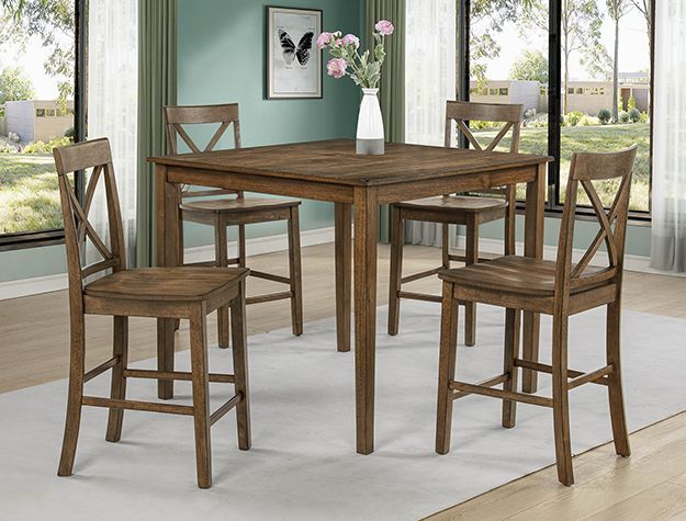Wooden dining table with four tall chairs in a bright room with green walls and windows