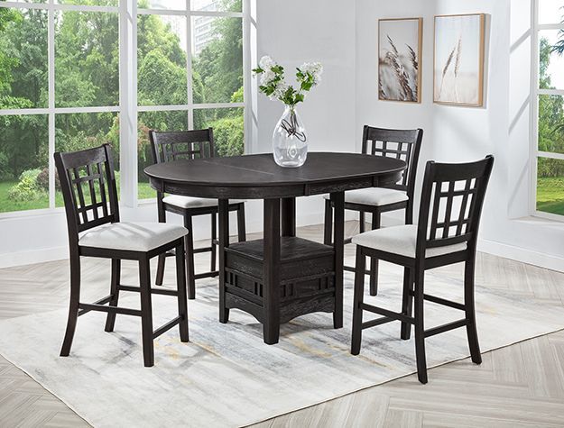 Dark wood dining table with four chairs in a bright room with large windows and a vase centerpiece