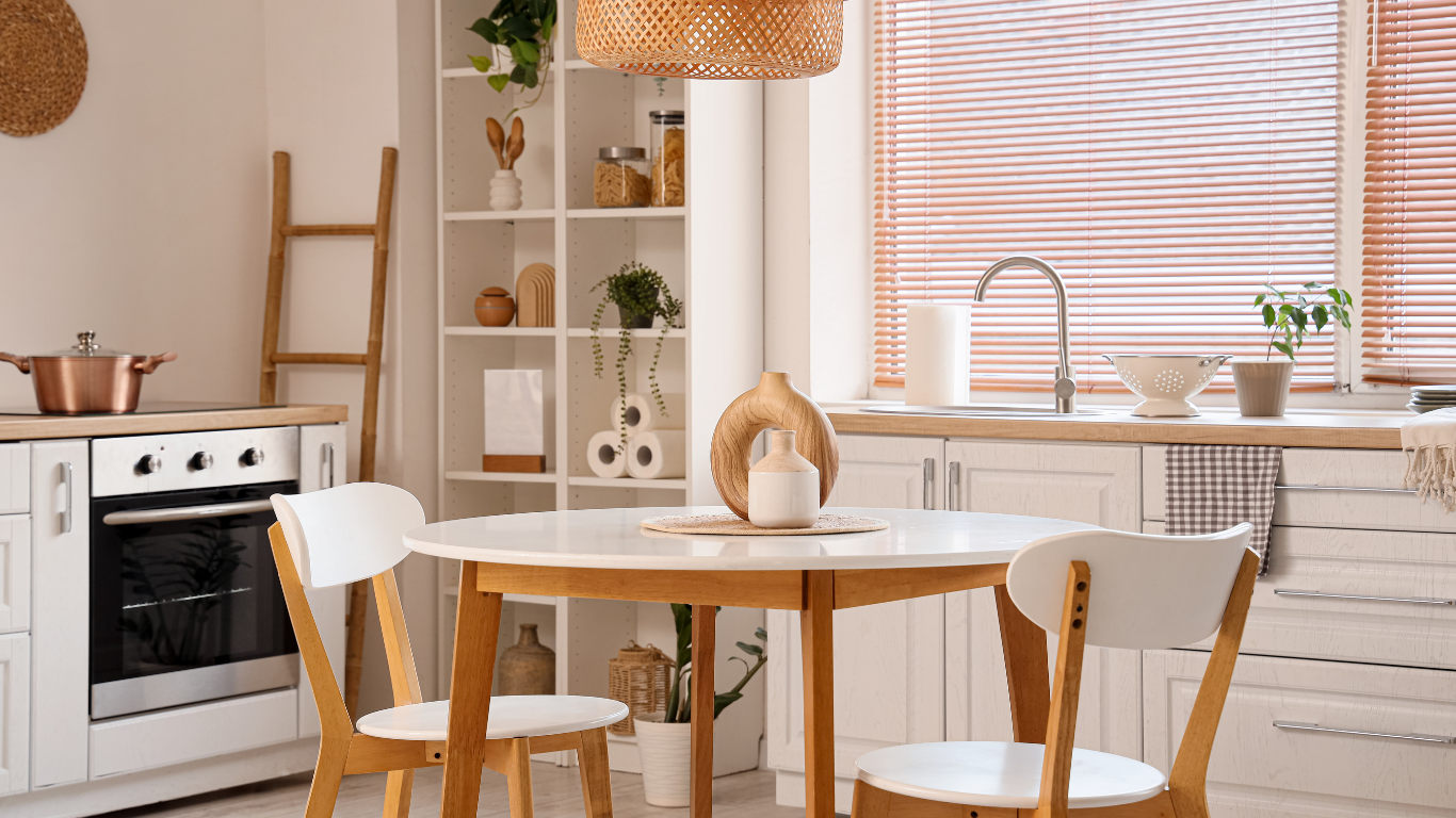 Cozy kitchen with round table, white chairs, stove, shelves, and a sunlit window with blinds