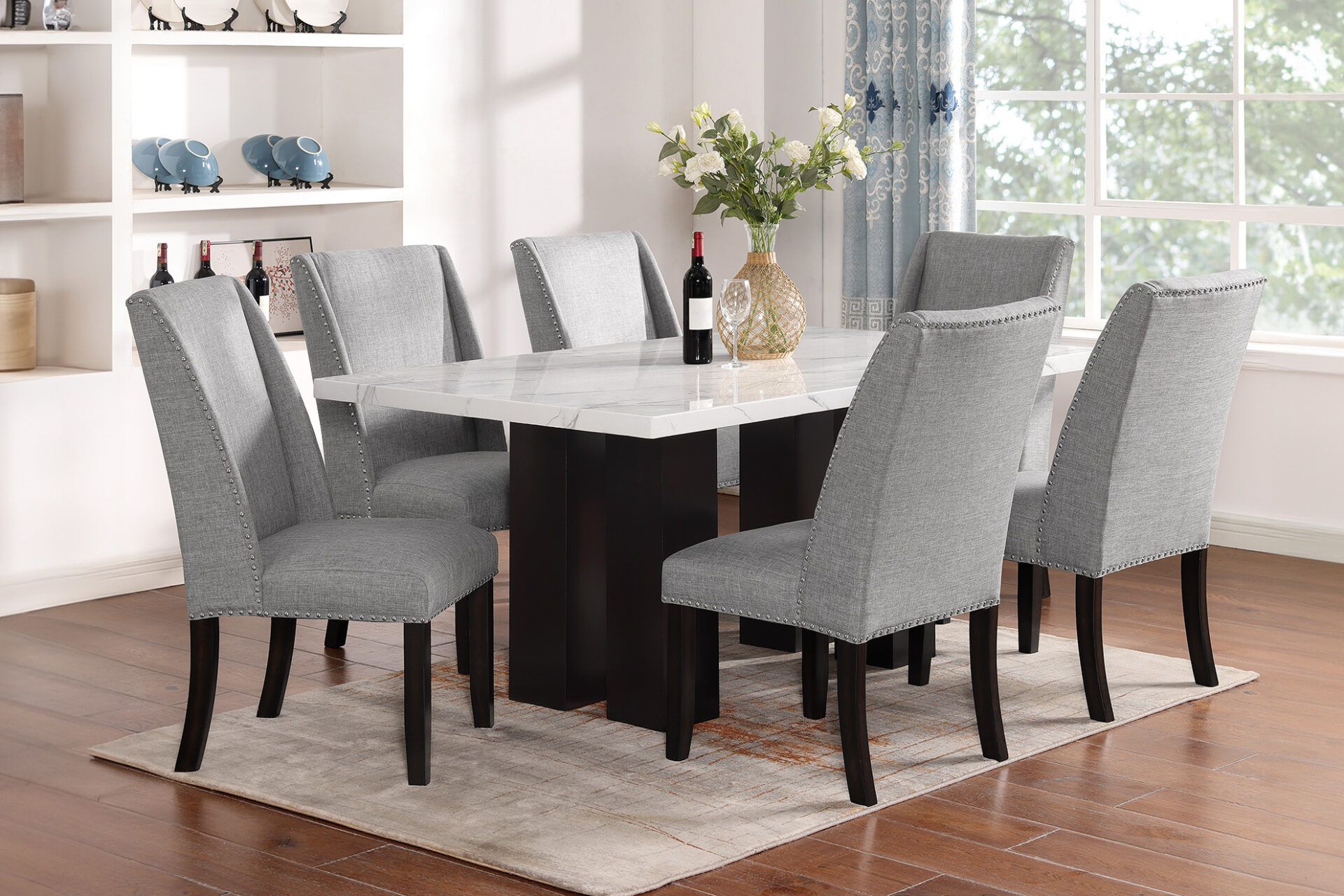 Modern dining room with a dark wood table, gray upholstered chairs, and a white vase centerpiece