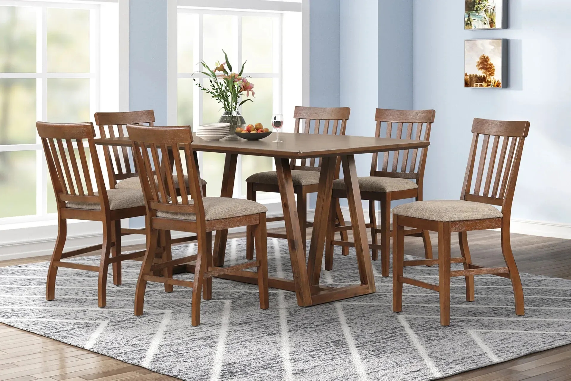 Wooden dining table with six chairs in a bright room by large windows