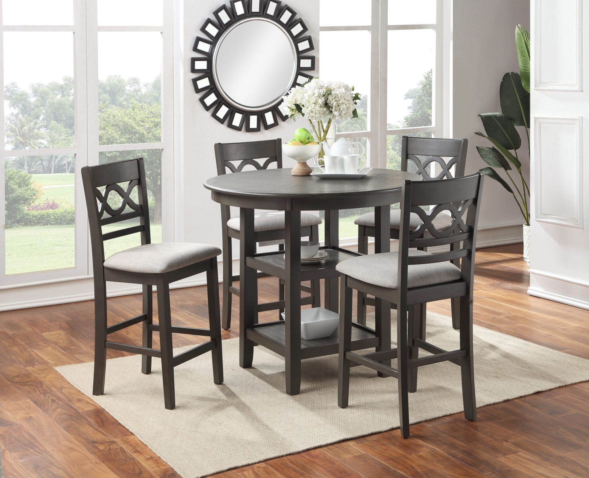 Dark wood dining table with four chairs in a bright, modern dining room near large windows