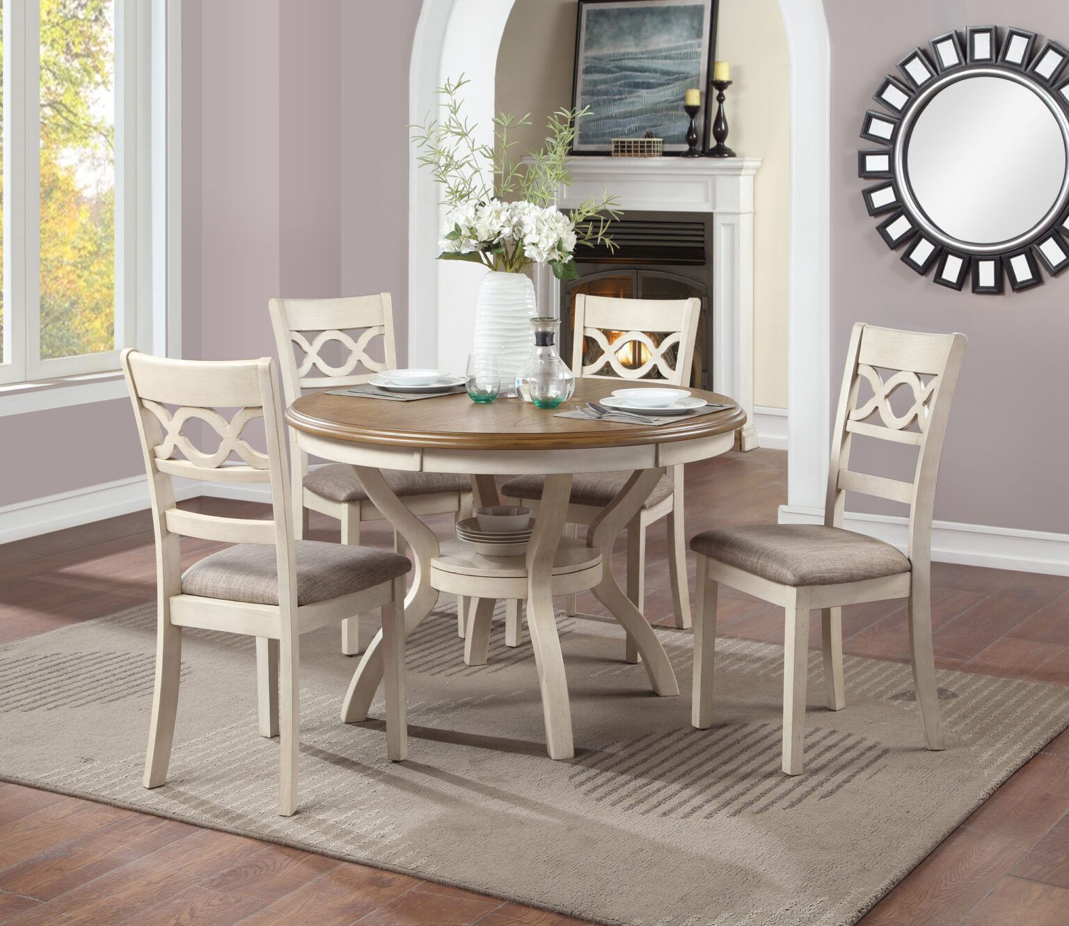 Round white dining table with four chairs in a bright, neutral dining room