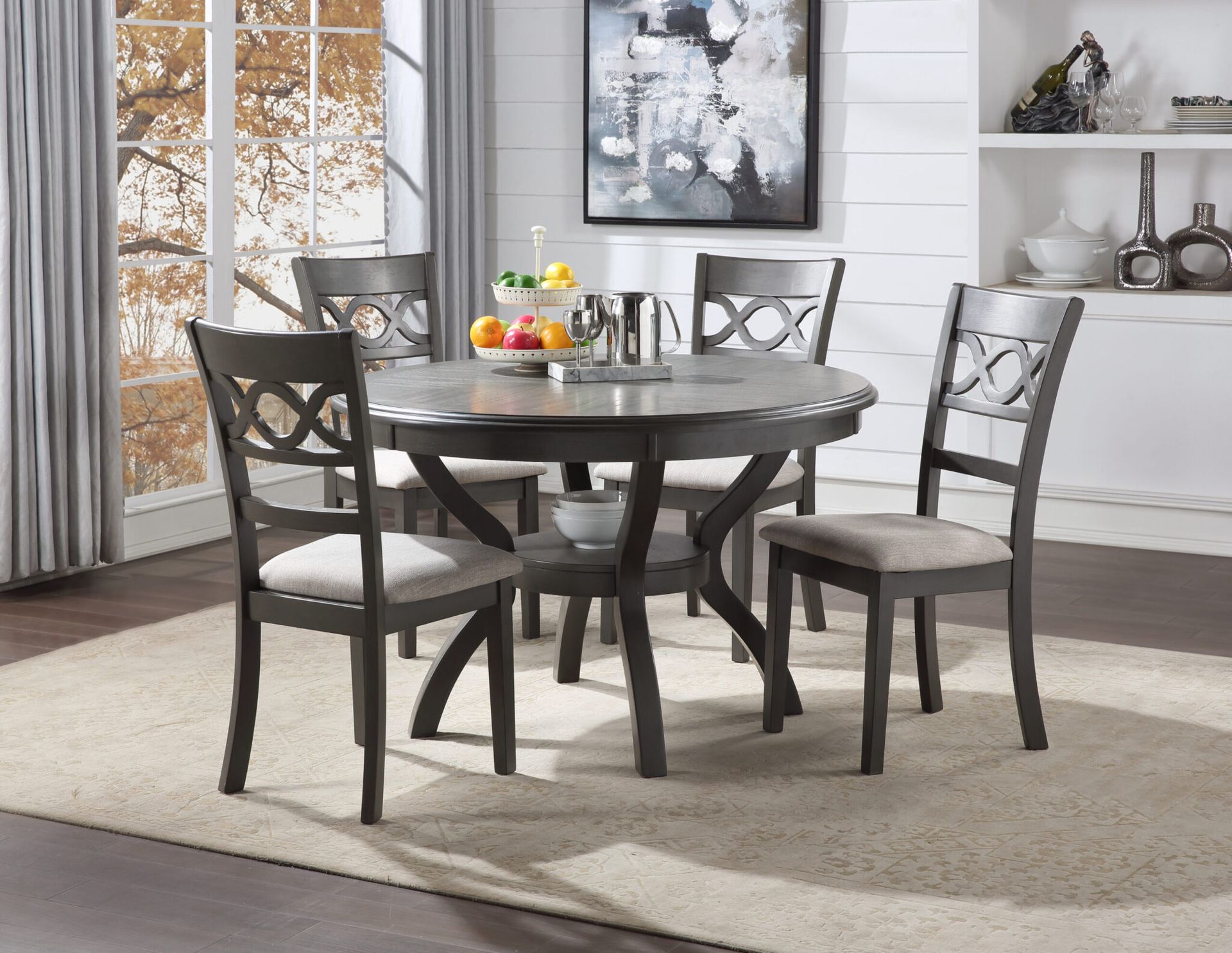 Round dining table with four gray chairs in a bright, modern dining room